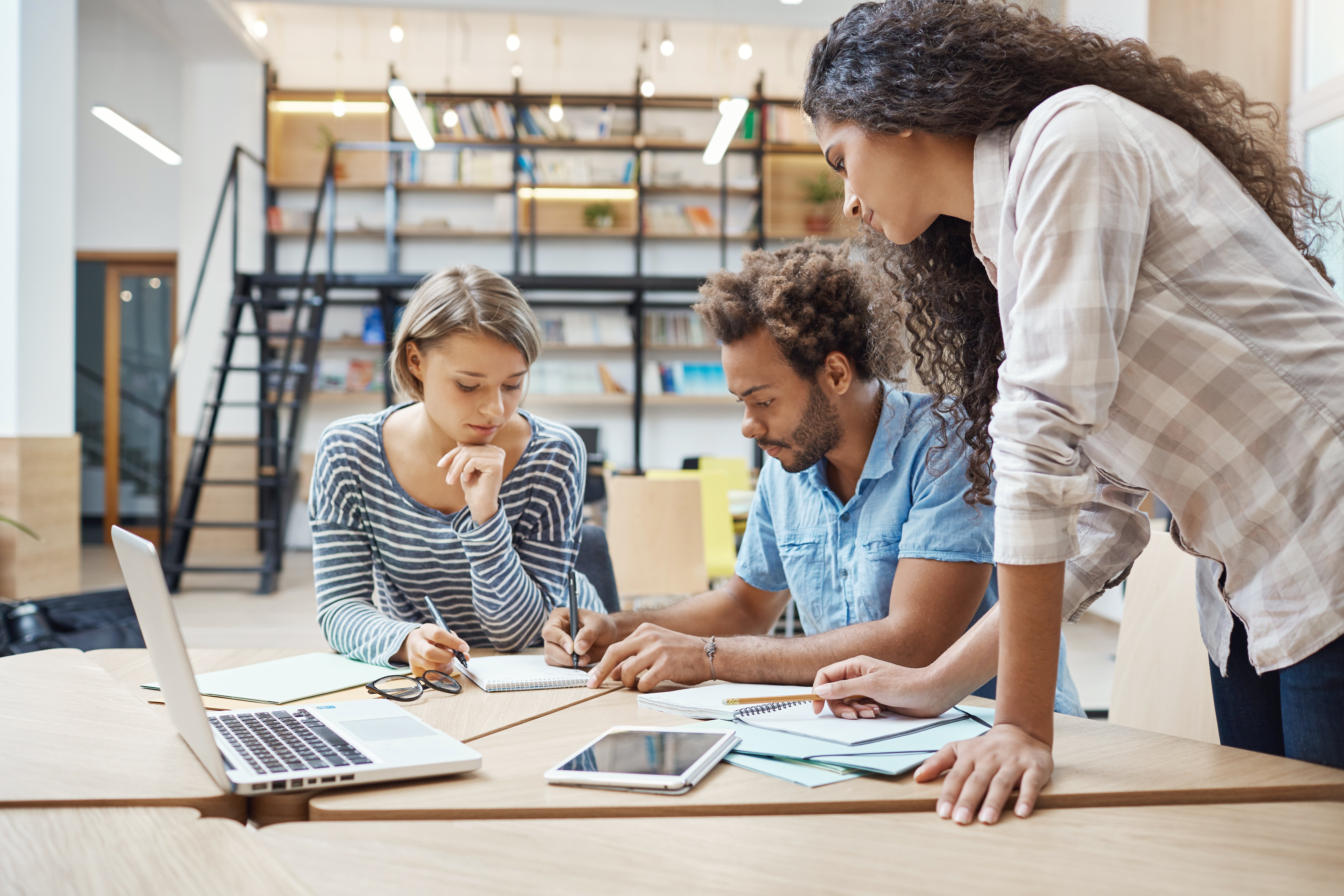 group-three-young-multi-ethnic-successful-business-people-sitting-coworking-space-talking-about-new-project-competitor-team-making-plans-bypass-their-project